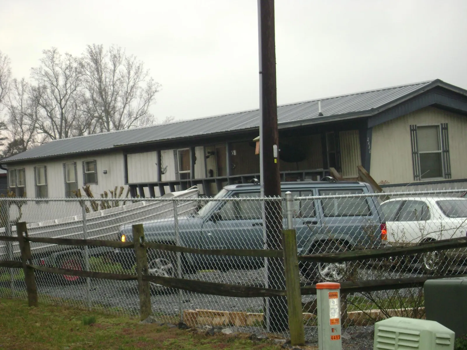Dark metal roof on a long single story building behind a chain link fence in Deerfield